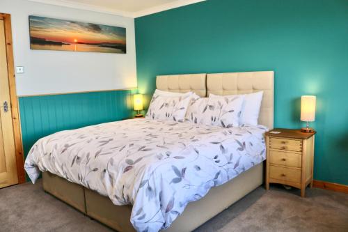 a bedroom with a bed with a blue wall at An-Airidh Bed & Breakfast Portree in Portree