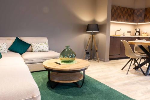 a living room with a couch and a table with a vase on it at Gite Au Coeur de Han in Han-sur-Lesse