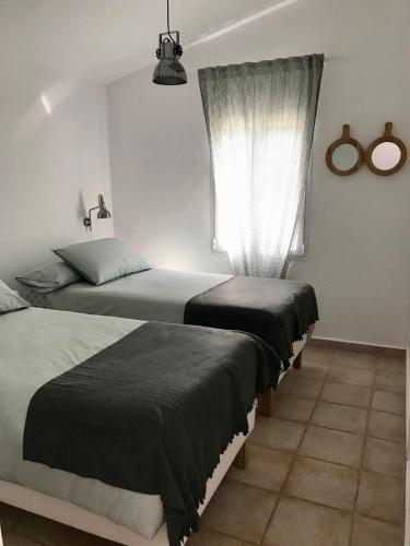 a bedroom with two beds and a window at Chalet La Rosa in Cala Blanca