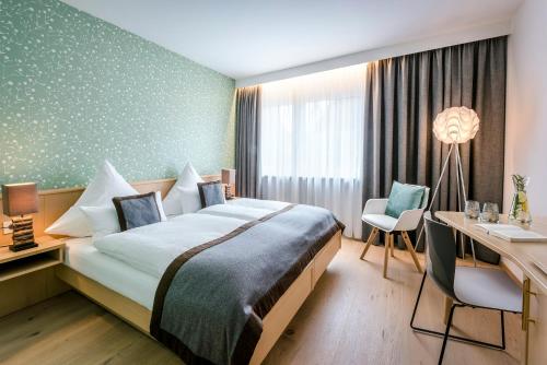 a hotel room with a bed and a desk at Hotel Krone in Bretten