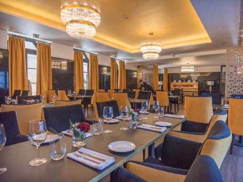 a restaurant with tables and chairs and chandeliers at Hotel República Boutique Hotel in Tomar