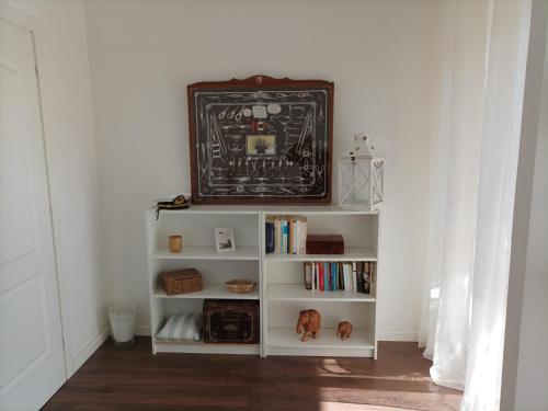 ein weißes Bücherregal mit einer Uhr darüber in der Unterkunft "StayEasy" Apartment in Sant'Agnello