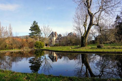 einen Teich in einem Park mit einem Haus im Hintergrund in der Unterkunft Château de la Combe in La Celle