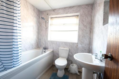 a bathroom with a white toilet and a sink at Swansea Cosy Stay in Swansea