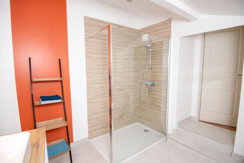 une douche avec une porte vitrée dans une salle de bain dans l'établissement Les Rêveries de la Tour, à Vermenton