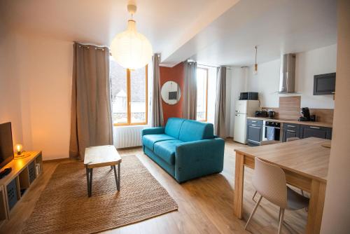 un salon avec un canapé bleu et une table dans l'établissement Les Rêveries de la Tour, à Vermenton