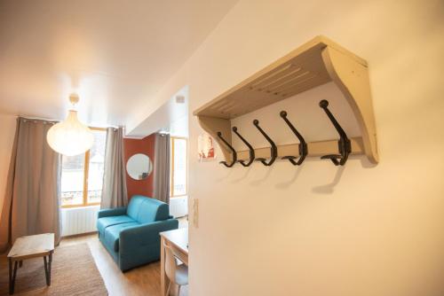 Cette chambre comprend un réfrigérateur et une chaise bleue. dans l'établissement Les Rêveries de la Tour, à Vermenton