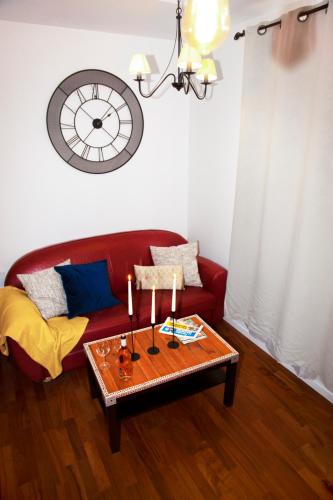 a living room with a red couch and a table with candles at Les Lofts De Provins Apt 2 in Provins