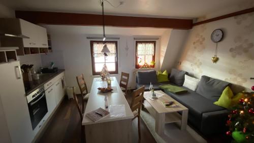 eine Küche und ein Wohnzimmer mit einem Sofa und einem Tisch in der Unterkunft Froeschlein 2 - no Gitters & craftsman in Ilmenau