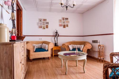 sala de estar con sillas de mimbre y mesa en Casa de Pueblo, en Martos