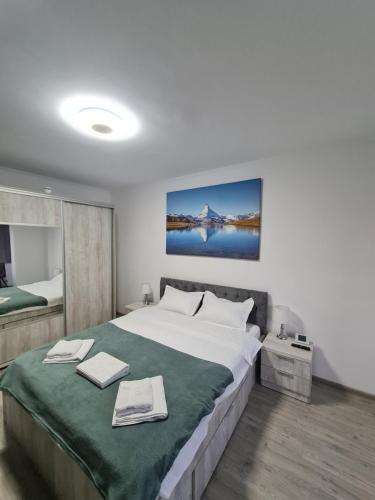 um quarto com uma cama grande e um cobertor verde em Smart Apartament em Braşov
