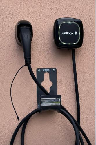 a black cord plugged into a charger on a wall at Pension Altstadt Garni in Bad Windsheim