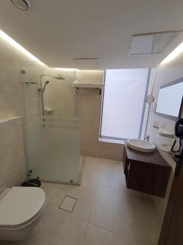 a bathroom with a toilet and a shower and a sink at Al Salam Hotel in Kuwait