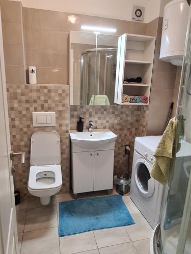 uma casa de banho com um WC, um lavatório e uma máquina de lavar roupa em Apartment UNA Sarajevo em Sarajevo