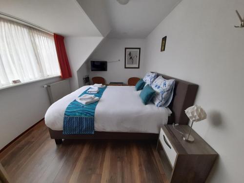 een slaapkamer met een bed en een tafel met een lamp bij Hotel Bed & Breakfast De Poffert in Borger