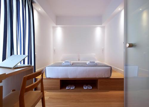 a bedroom with a bed and a desk and a chair at Porto Veneziano Hotel in Chania Town