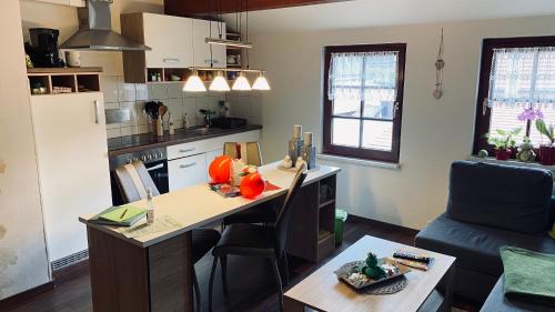 a kitchen with a desk and a table in a room at Froeschlein - no craftsmen fitters in Ilmenau