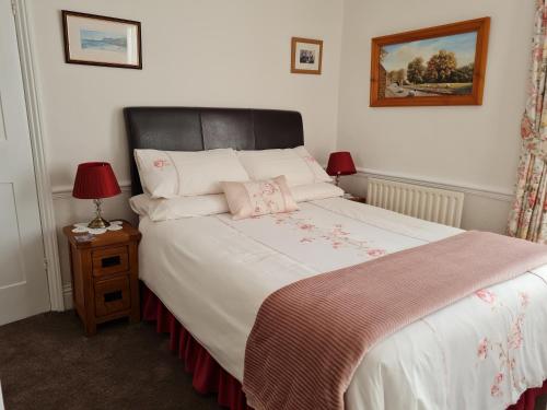 a bedroom with a large bed with two lamps on a table at Rowan Tree House B&B in Sleights