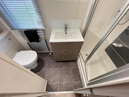 a small bathroom with a sink and a toilet at Lakes End, Dog Friendly in South Cerney