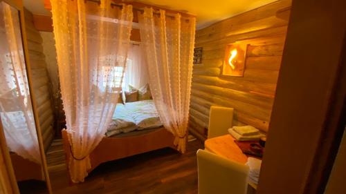 a bedroom with a bed with curtains and a table at Froeschlein 2 - no Gitters & craftsman in Ilmenau