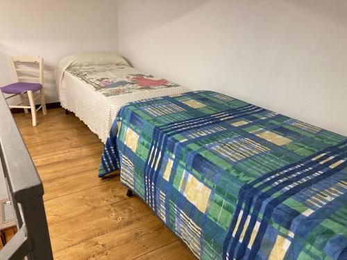 - une petite chambre avec un lit et une chaise dans l'établissement Corso Garibaldi, à Scordia