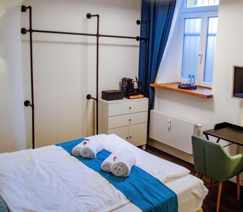 ein Schlafzimmer mit einem Bett mit Handtüchern darauf in der Unterkunft HOMELY STAY Studio 2 in München