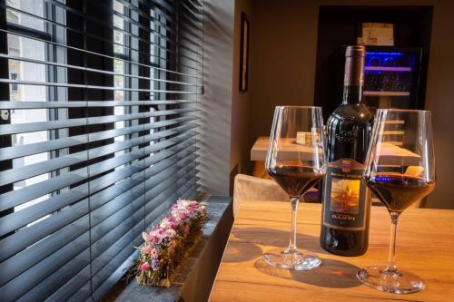a bottle of wine and two wine glasses on a table at B&B Au Cœur de Han in Han-sur-Lesse