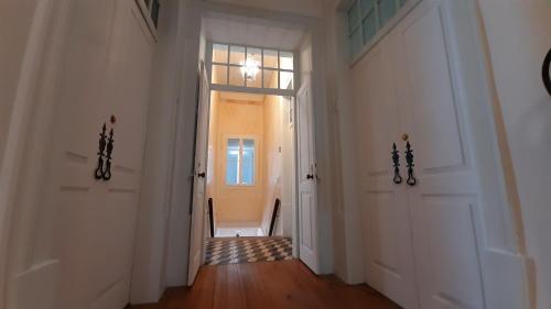 a hallway with a door and a chair in a room at A Casa do Tenente in Faro