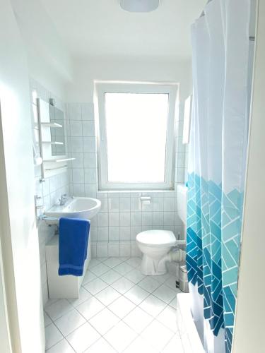 La salle de bains est pourvue de toilettes, d'un lavabo et d'une fenêtre. dans l'établissement Blaue Insel neben Hbf-Duisburg, à Duisbourg