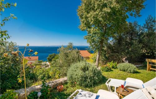 a garden with chairs and a view of the ocean at Stunning Apartment In Stara Baska With Wifi in Stara Baška