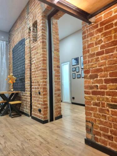 an empty room with a brick wall and a table at Old Town #Menorah #MostCity in Dnipro