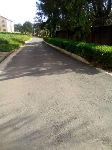 an empty road with trees on the side of it at Kampala Ntinda Comfy Holiday Home in Kampala