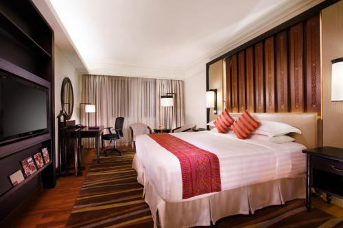 a hotel room with a large bed and a flat screen tv at PARKROYAL Yangon in Yangon