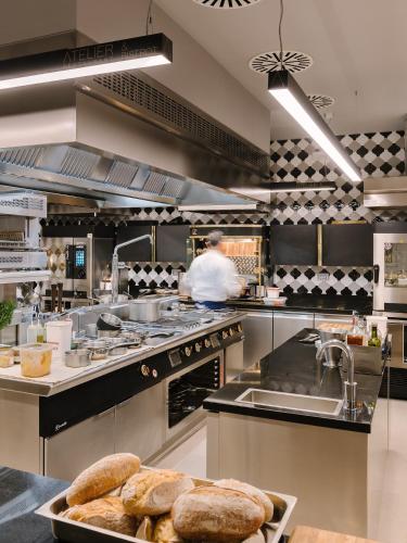 a kitchen with a person preparing food in a kitchen at Hotel Ristorante Eurossola in Domodossola
