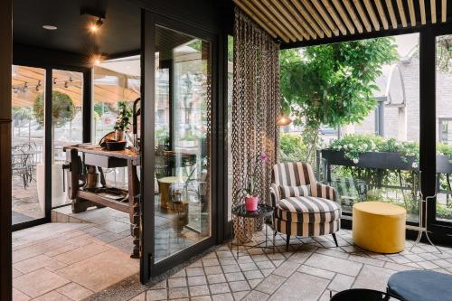 a screened porch with a chair and a table at Hotel Ristorante Eurossola in Domodossola