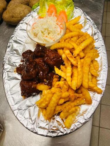 a plate of food with french fries and coleslaw at Gasthaus Dernedde in Osterode