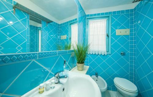 ポルト・チェルボにある[PORTO-CERVO]Casa con piscina e vista yachtsの青いバスルーム(洗面台、トイレ付)
