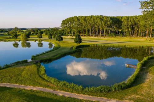 an aerial view of a golf course with a pond at Beatrix Apartments in Bük