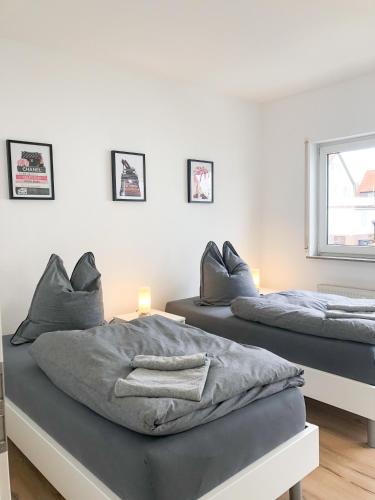 two beds in a white room with at Deluxe Apartments Messe Flughafen in Leinfelden-Echterdingen