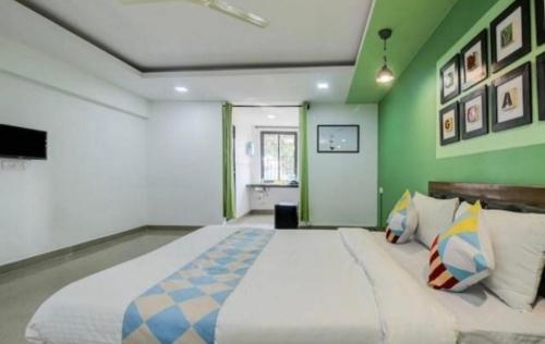 a large bed in a room with green walls at Hotel Sai Advika in Mapusa