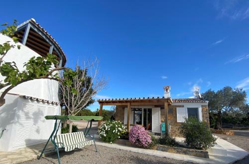 a house with a table and a bench in front of it at CASA DA PEDRA-QUINTA DOS CEDROS-TAVIRA in Tavira