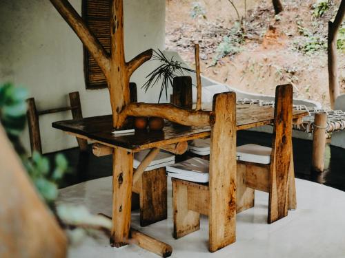 a wooden table with a chair and a table with a tree at Ella Retreat Cottage for Nature Lovers in Ella