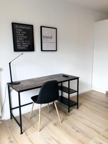 a black desk with a black chair and a chalkboard at Deluxe Apartments Messe Flughafen in Leinfelden-Echterdingen