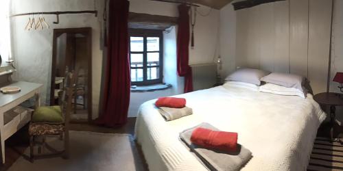 a bedroom with a large bed with red and white pillows at The Tavern in Castelnau-Pégayrols