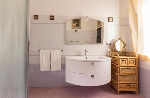 Un baño blanco con lavabo y espejo. en Terrazza Ionica - Apartment Sea View Wifi, en Siracusa