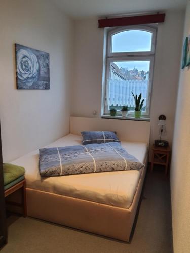 a small bedroom with a bed and a window at Ferienwohnung Döring in Erfurt