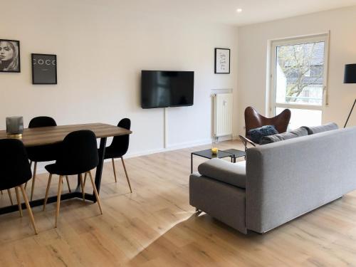 a living room with a couch and a table at Deluxe Apartments Messe Flughafen in Leinfelden-Echterdingen