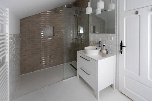 uma casa de banho com um lavatório, um chuveiro e uma banheira em Hygge Loft Bucovina em Vama