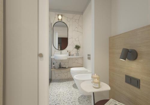 a bathroom with a toilet and a sink and a mirror at Hotel Sirenetta in Grado