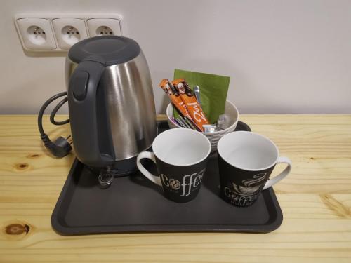 two coffee cups on a tray on a counter at Wellness Hotel Koliba in Komorní Lhotka
